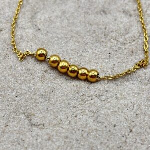 Goudkleurig enkelbandje met bolletjes